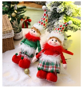Detailed view of red and green plush Christmas elf dolls on a cozy snow-covered background