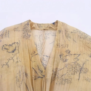 Fashion vintage top with lantern sleeves, deep V-neck, and blue floral print on yellow fabric