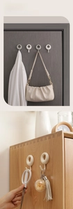 Detail of self-adhesive round hooks on doors and cabinets for hanging bags and towels