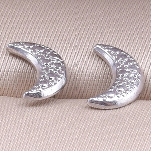 Detailed view of handmade moon-shaped studs in 304 stainless steel with hammered texture