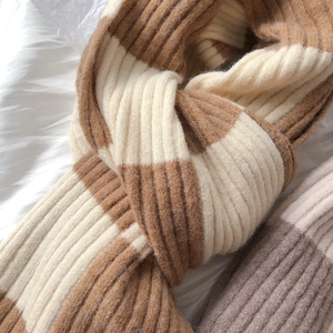 Close-up of thick checkered knit scarf showing brown and white striped yarn texture