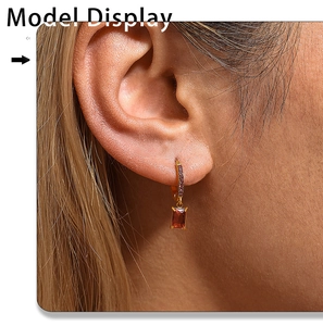 Close-up of 18K gold plated drop earring with red zircon stone and small pink diamonds
