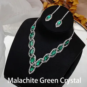 Detail of bridal necklace and earrings set with emerald green marquise crystals and pavé stones