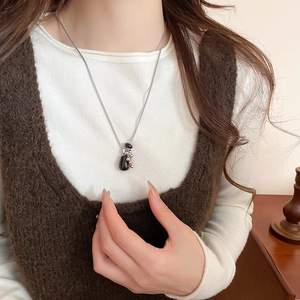 Detail of tiger eye stone tassel necklace with silver beads on a dark pendant