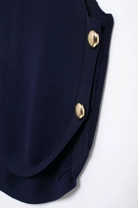 Detail view of blue knit vest featuring side texture and golden round button accents