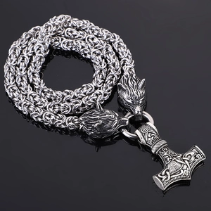 Detailed view of Viking Mjolnir pendant with braided chain and carved wolf head clasps