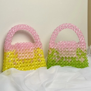 Close-up of handmade beaded handbags with floral patterns in pink, green, and yellow