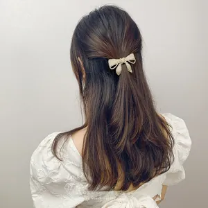 Close-up of elegant bow hair clip with white pearls worn on back of head