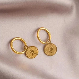 Golden titanium steel hoop earrings with Elizabeth II coin pendants on purple satin