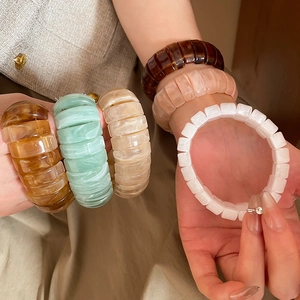 Macro shot of colorful resin bracelets set showing marble textures and amber finishes