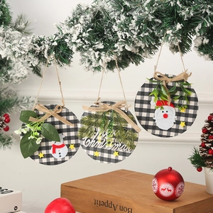 Detailed view of three checkered Christmas ornaments hanging on a snowy branch
