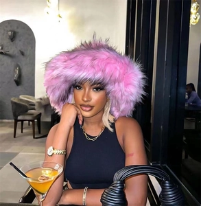 Detail of pink faux fur trapper hat with fluffy long hair texture in a modern cafe setting