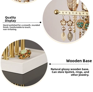 Detail of gold jewelry organizer with white wooden base and hooks for earrings