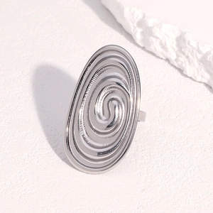 Minimalist silver spiral textured open ring in stainless steel on white stone background