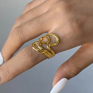 Detail of layered gold wave ring with mirror finish on model finger
