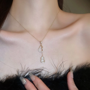 Détail du collier pendentif Hulu doré avec cristaux de zircon et pierre œil de chat blanche