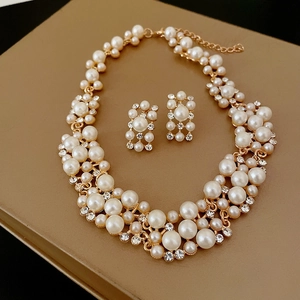 Vintage jewelry set with pearl necklace and rhinestone earrings on golden stand