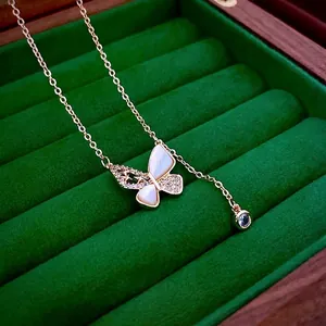 Elegant gold-plated necklace with a zirconia butterfly pendant on green velvet