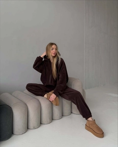 Dettaglio di un completo in pile marrone scuro con felpa e pantaloni su modella