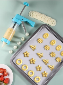 Detail of blue cookie press gun with various white nozzles for DIY baking decoration