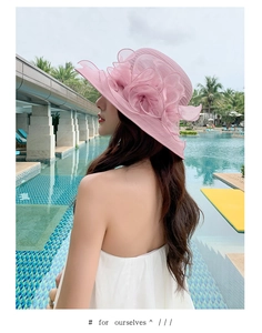 Detail of pink organza wide brim sun hat with large floral accent by a pool
