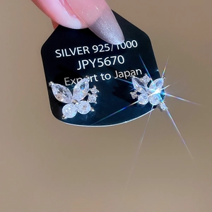 Detail of silver butterfly earrings with zircons and 925 silver studs on a display card