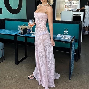 Détail de la dentelle florale rose et des bretelles fines sur une robe de soirée