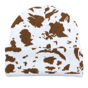 Brown and white cow print knit beanie hat with leopard jacquard texture on white background