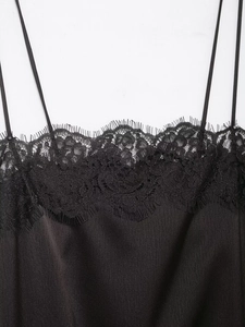 Détail d'un caraco en satin noir avec dentelle de cils délicate et fines bretelles