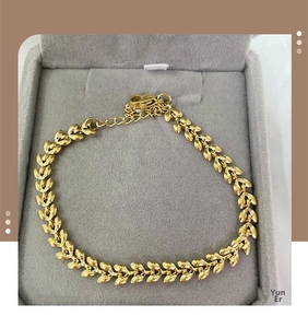 Detail of golden wheat leaf bracelet with matte finish and secure lobster clasp closure