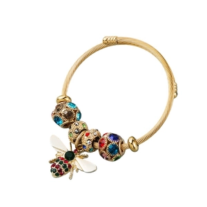 Detailed shot of golden braided bangle with crystal beads and bee charm pendant