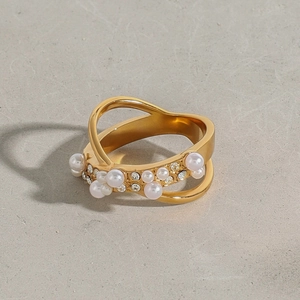 Détail de la bague en acier titane doré avec perles élégantes et strass scintillants