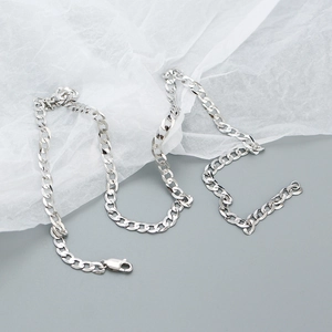 Detail of 925 silver curb chain necklace with a lobster clasp on white paper background