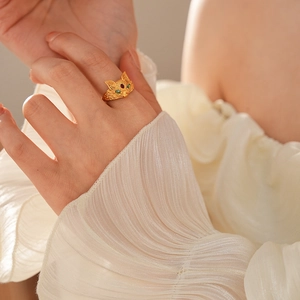 Close-up of 24k gold plated fox ring with green gemstone eyes and red crystal detail