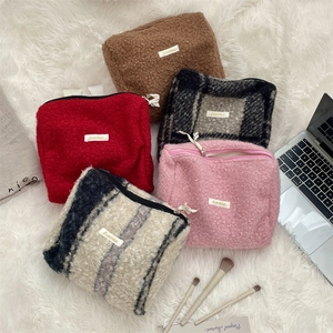 Detailoverzicht van kleurrijke pluizige bouclé fleece make-uptassen voor reis