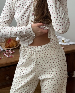 Detailed texture of ribbed floral pajama set with pink roses on off-white fabric