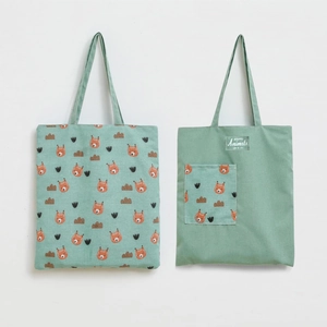 Detail view of mint green canvas tote bag featuring cute fox prints and functional pocket