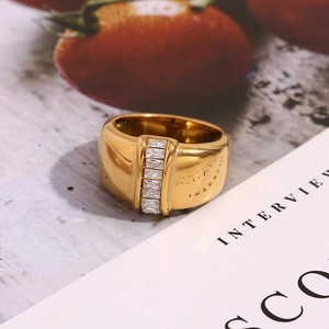 Detailed macro of wide 18K gold plated ring featuring vertical baguette-cut crystals