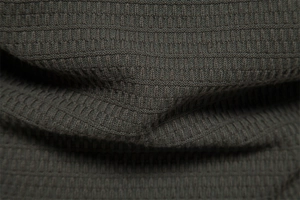 Macro shot of dark olive waffle knit fabric showing texture and thickness of the men cardigan
