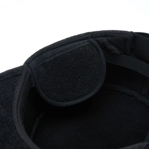 Macro detail of warm black wool flat cap showing thermal lining and adjustable ear flaps