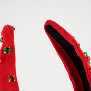 Detailed shot of red fabric headband with festive gemstone inlay and non-slip lining