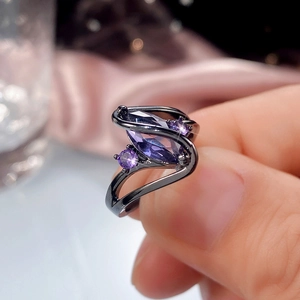 Detailed view of marquise-cut purple zircon ring with gun black plating on finger