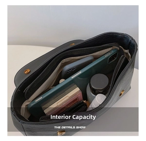 Internal view of the black leather handbag showing large capacity and multi-compartments