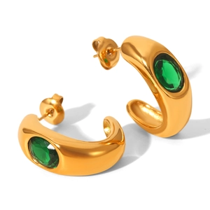 Macro detail of 18K gold C-shape chunky earrings set with oval green zircon stones