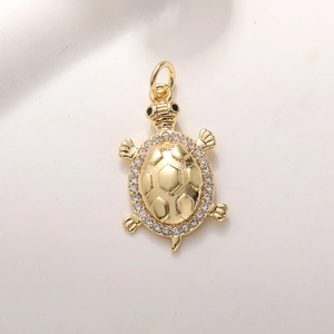 Macro-opname van de vergulde schildpadbedel met ingelegde witte en zwarte zirkonia's