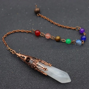 Macro view of white crystal hexagonal pendulum with copper chakra beads on the chain