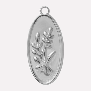 Close-up of vintage oval stainless steel pendant with embossed leaf branch pattern