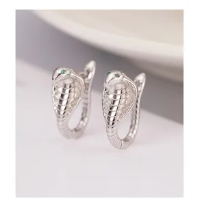 Macro view of S925 sterling silver cobra earrings with green zircon eyes and scale texture