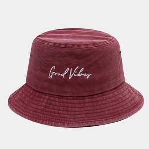 Détail de la broderie 'Good Vibes' blanche sur un bob en coton bordeaux délavé