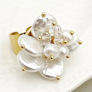 Elegant gold-plated flower ring with baroque pearls and crystal accents on ceramic base